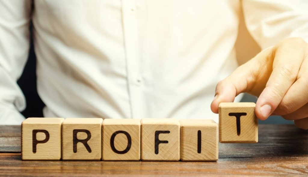 businessman puts wooden blocks with the word profit 1024x590 1