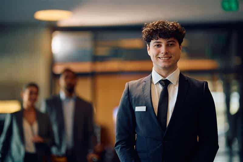 Recepcionista de hotel atendiendo con una sonrisa